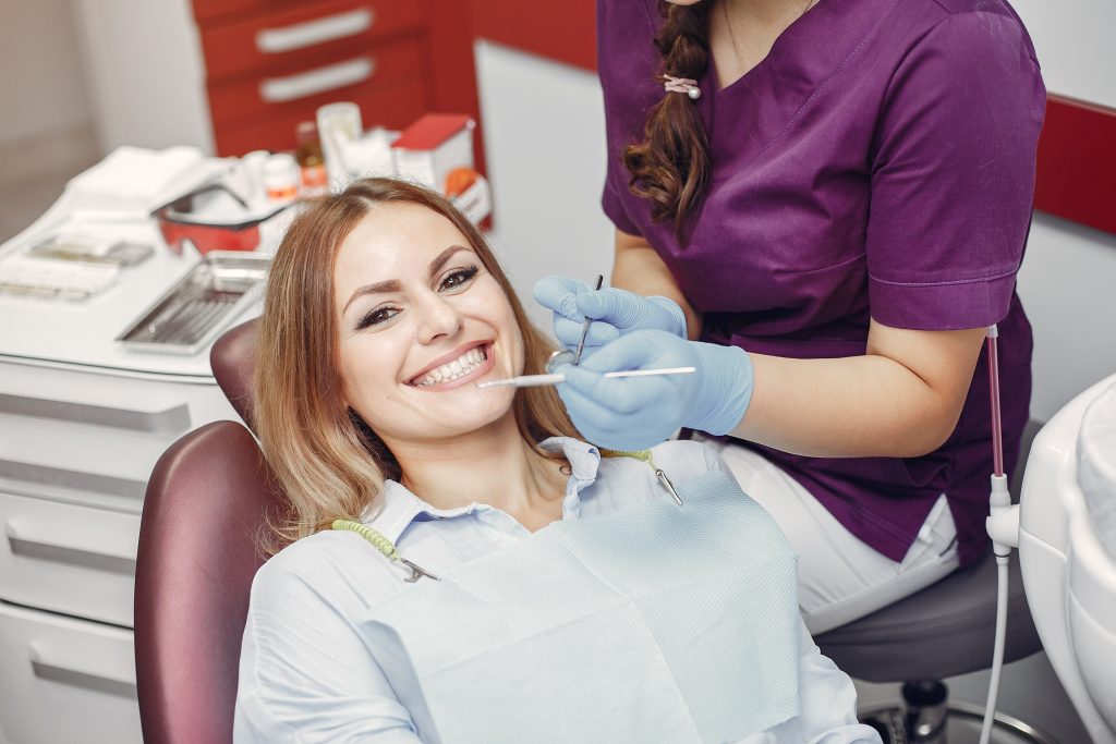 Beautiful lady in the dentist's office. Woman in a purple uniform