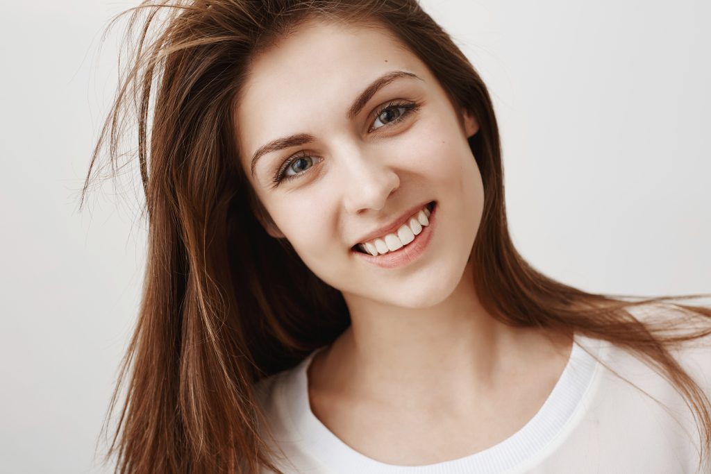 Friendly woman ready to help and give advice. Close-up portrait of sensual good-looking female tilting head and smiling broadly, expressing interest and relax, being happy talking with boyfriend. Copy space